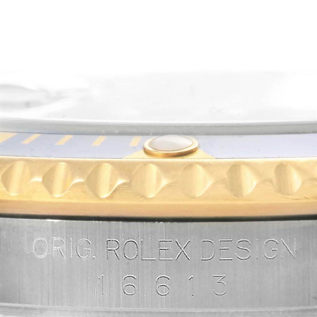 Close-up view of the case and bezel of the Rolex Submariner 16613 Men's Steel and Gold (two tone) Blue Dial 16613 Men's Steel and Gold (two tone) Blue Dial model, showing the engraved serial number and bezel details.