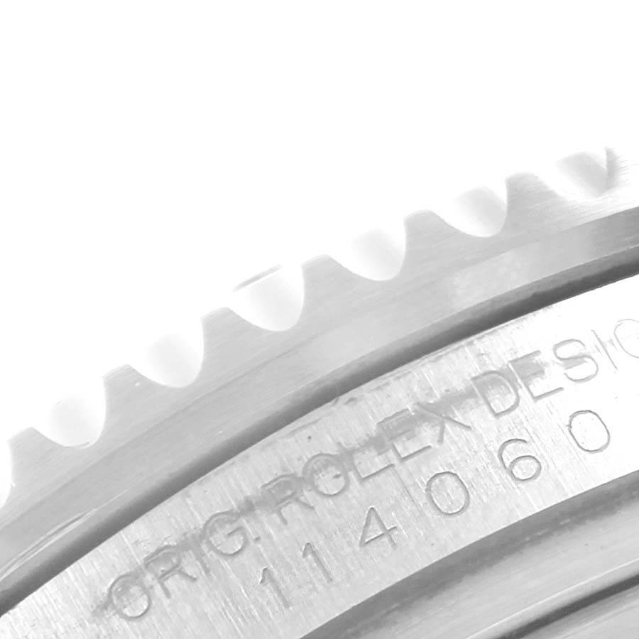 This close-up image shows the engraved case and part of the bezel of the Rolex Submariner 114060 Men's Stainless Steel Black Dial 114060 Men's Stainless Steel Black Dial watch.
