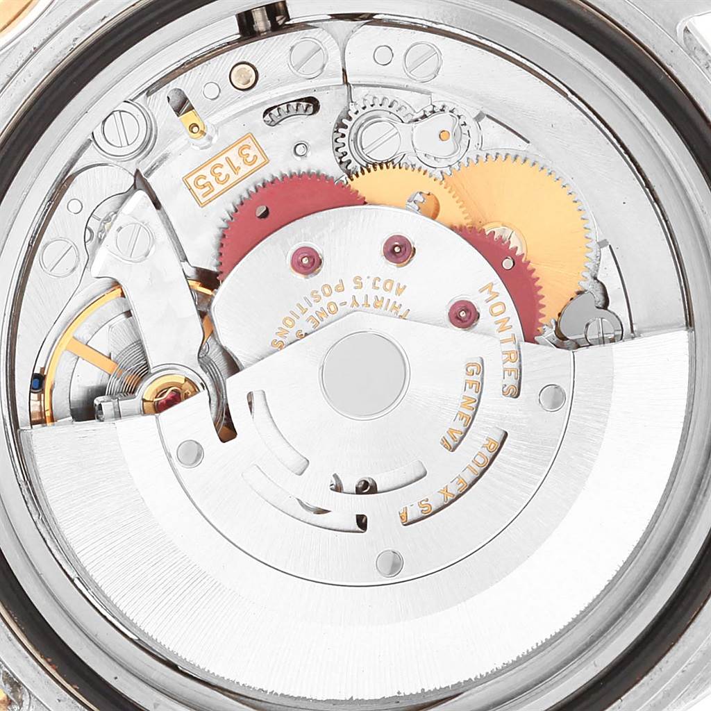 This image shows the intricate inner workings of a Rolex Submariner 16613 Men's Steel and Gold (two tone) Blue Dial 16613 Men's Steel and Gold (two tone) Blue Dial watch, focusing on the movement and gears from a top-down angle.