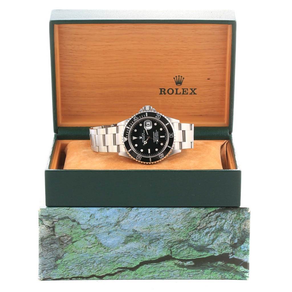 This image shows a Rolex Submariner 16610 Men's Stainless Steel Black Dial 16610 Men's Stainless Steel Black Dial watch placed inside an open Rolex box, viewed from the front.