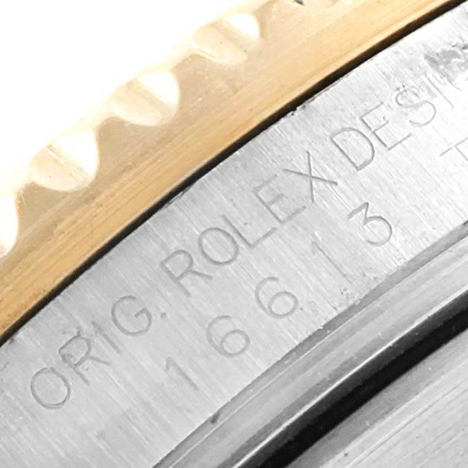 This close-up image shows the side view of the bezel and part of the case with engraved text of the Rolex Submariner 16613 Men's Steel and Gold (two tone) Grey Dial 16613 Men's Steel and Gold (two tone) Grey Dial watch.
