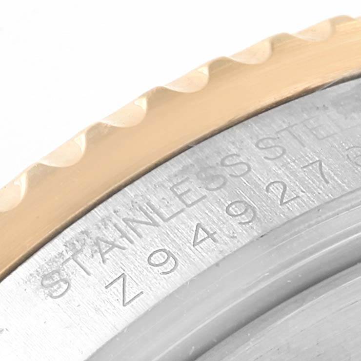 Close-up of the bezel and the engraved caseback of a Rolex Submariner 16613 Men's Steel and Gold (two tone) Grey Dial 16613 Men's Steel and Gold (two tone) Grey Dial watch, showing the edge and serial number.