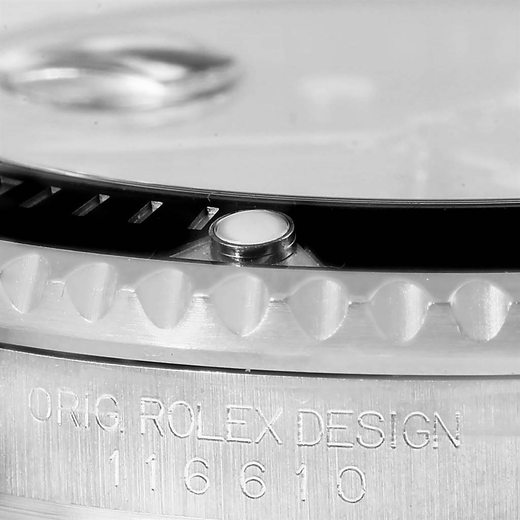 This close-up image shows the Rolex Submariner 116610 Men's Stainless Steel Black Dial 116610 Men's Stainless Steel Black Dial's bezel with its characteristic notched edge and part of the engraved serial number.