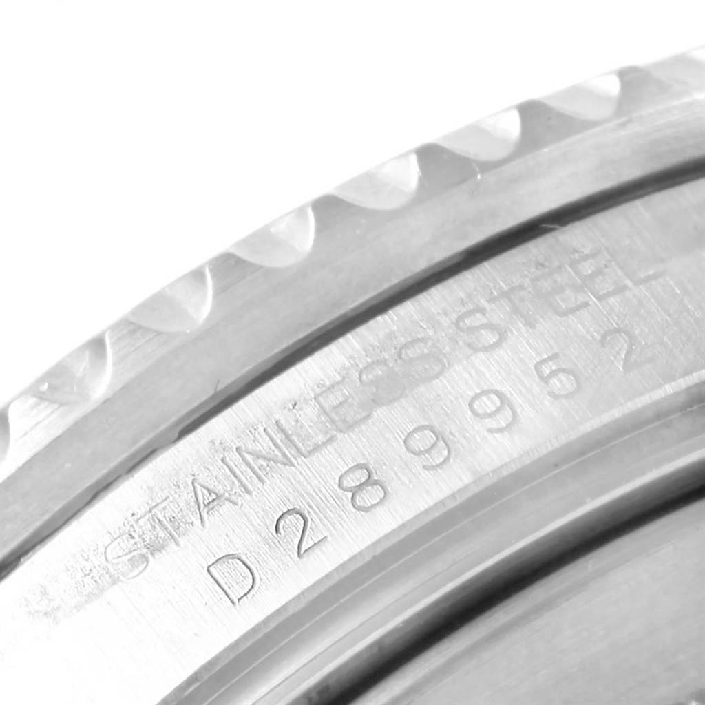 The image shows a close-up of the edge of a Rolex Submariner 16610 Men's Stainless Steel Black Dial 16610 Men's Stainless Steel Black Dial watch, focusing on the bezel and engraved serial number.