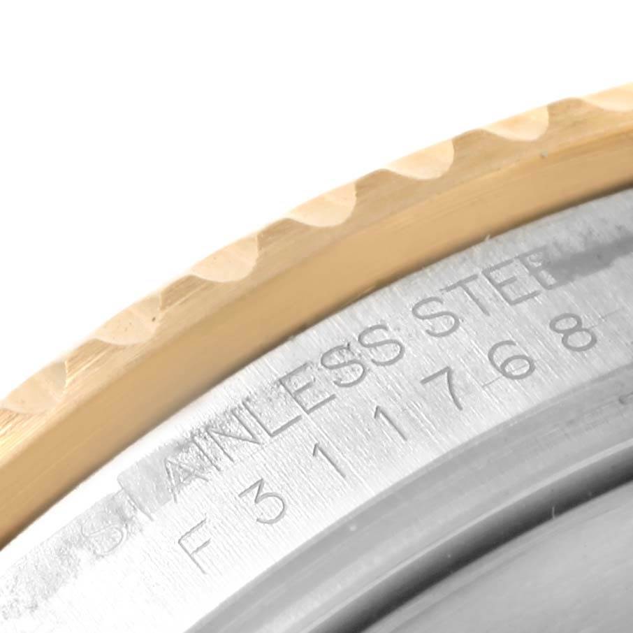 This close-up image shows the bezel edge and engraved case back of a Rolex Submariner 16613 Men's Steel and Gold (two tone) Blue Dial 16613 Men's Steel and Gold (two tone) Blue Dial watch.