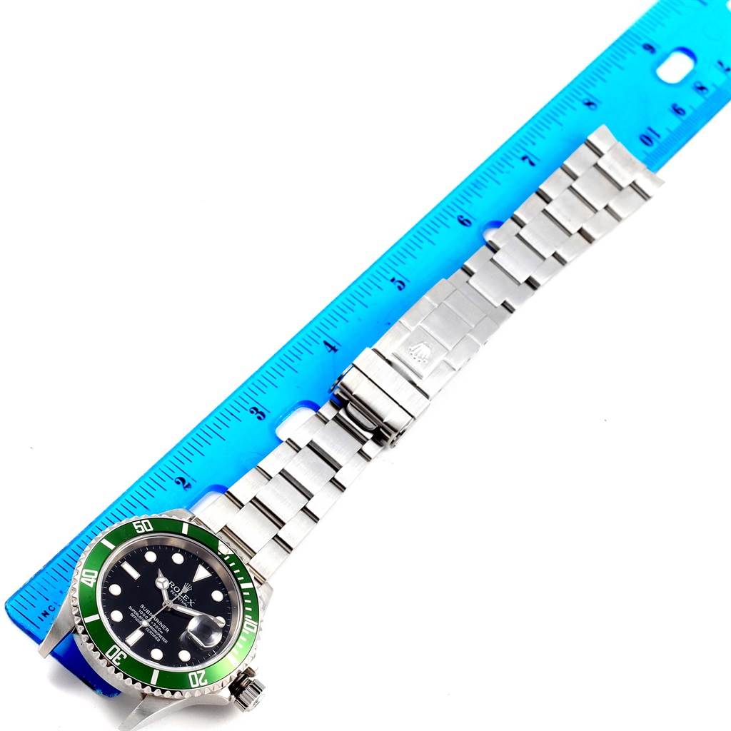 The Rolex Submariner 16610LV Men's Stainless Steel Black Dial 16610LV Men's Stainless Steel Black Dial watch is shown flat, with the bracelet extended and a ruler beside it for measurement.