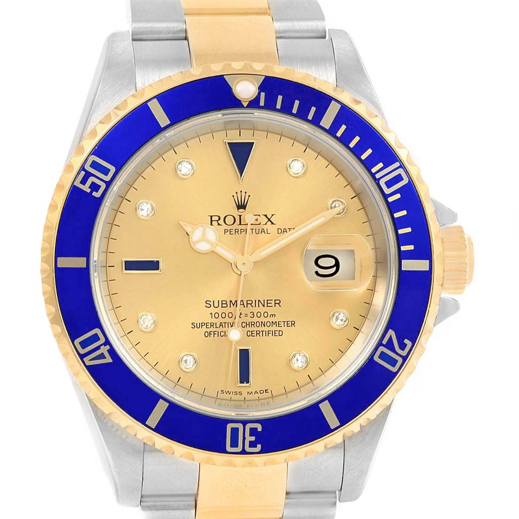The image shows a front angle of a Rolex Submariner 16613 Men's Steel and Gold (two tone) Champagne Dial 16613 Men's Steel and Gold (two tone) Champagne Dial watch, highlighting its gold dial, blue bezel, and two-tone metal bracelet.
