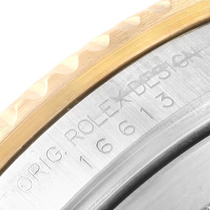 The image shows a close-up of the engraved watch case and bezel of the Rolex Submariner 16613 Men's Steel and Gold (two tone) Blue Dial 16613 Men's Steel and Gold (two tone) Blue Dial model.