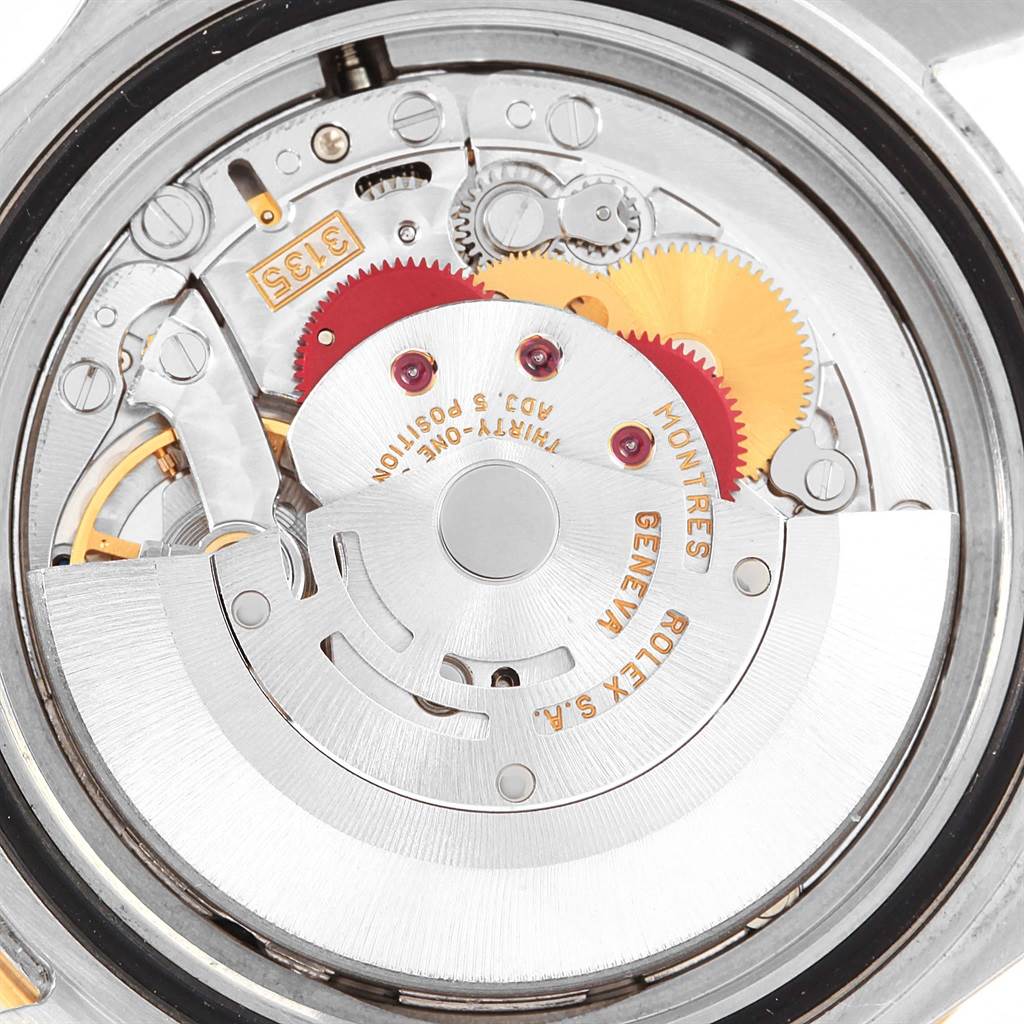 This image shows the intricate internal movement mechanism of a Rolex Submariner 16613 Men's Steel and Gold (two tone) Blue Dial 16613 Men's Steel and Gold (two tone) Blue Dial watch from a close-up, rear angle.