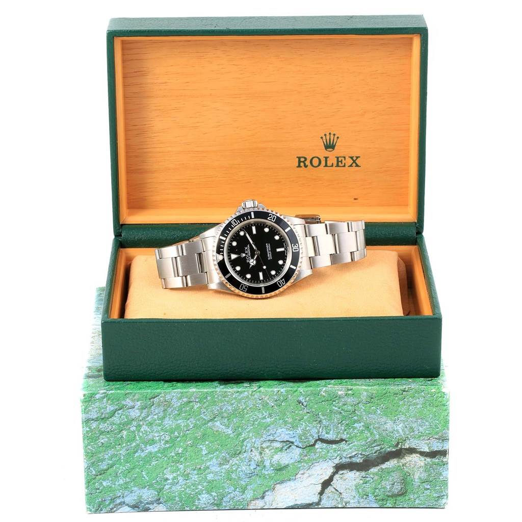 The Rolex Submariner 14060 Men's Stainless Steel Black Dial 14060 Men's Stainless Steel Black Dial watch is shown front-on, placed inside its branded box, which is open.