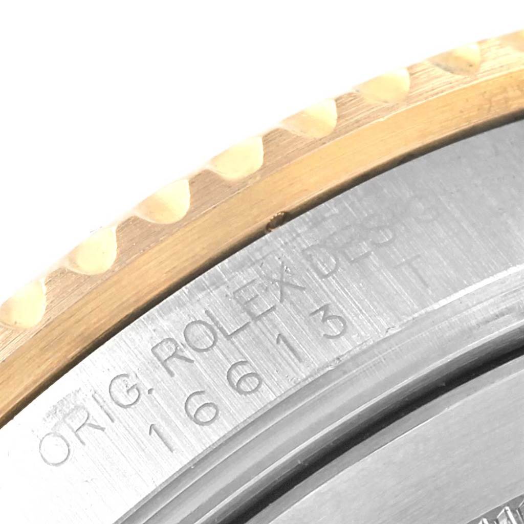 This close-up image shows the edge of the bezel and the engraved model details of a Rolex Submariner 16613 Men's Steel and Gold (two tone) Blue Dial 16613 Men's Steel and Gold (two tone) Blue Dial watch.