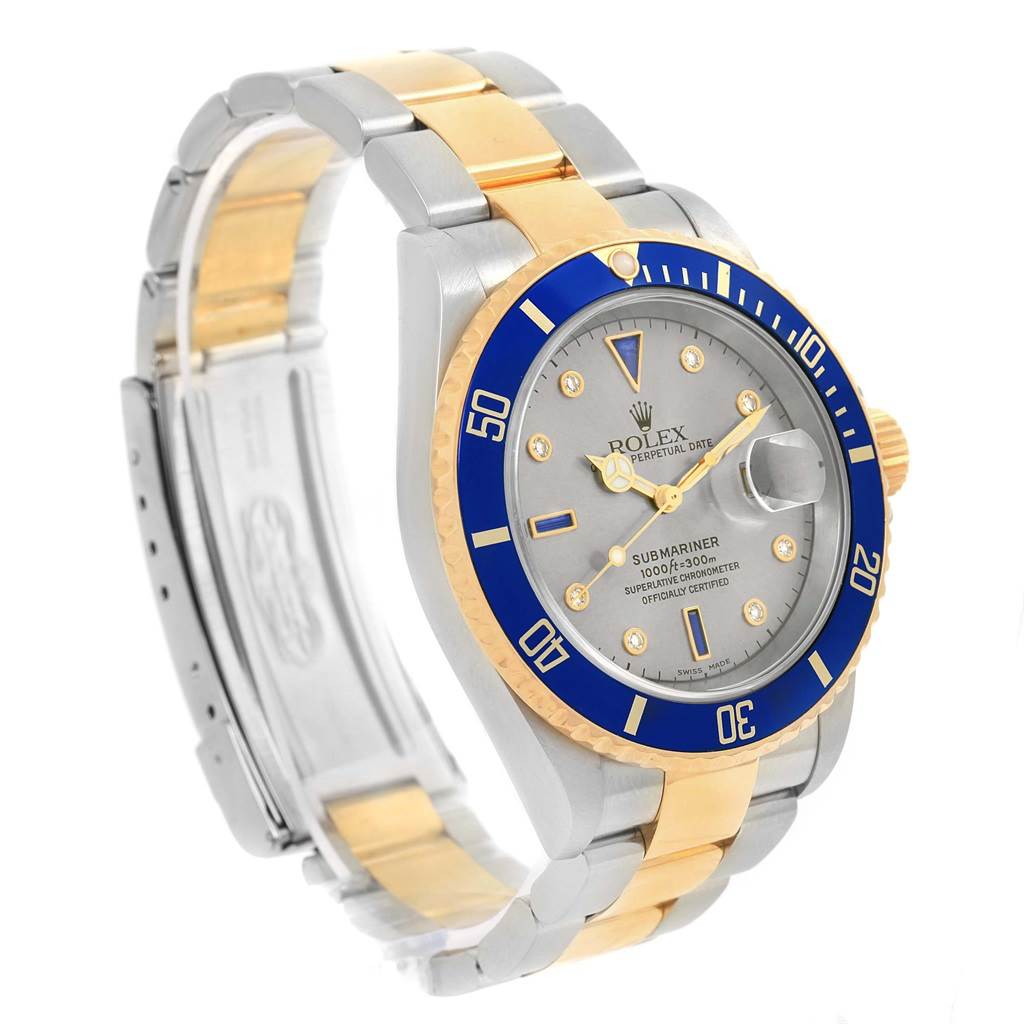 The Rolex Submariner 16613 Men's Steel and Gold (two tone) Grey Dial 16613 Men's Steel and Gold (two tone) Grey Dial watch is shown at a three-quarter angle highlighting the face, bezel, and partially extended two-tone bracelet.