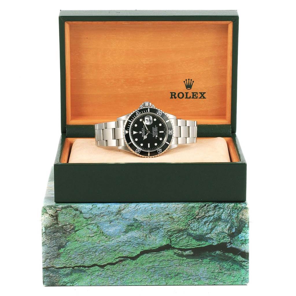 The Rolex Submariner 16610 Men's Stainless Steel Black Dial 16610 Men's Stainless Steel Black Dial watch is shown front and center in its open branded box.