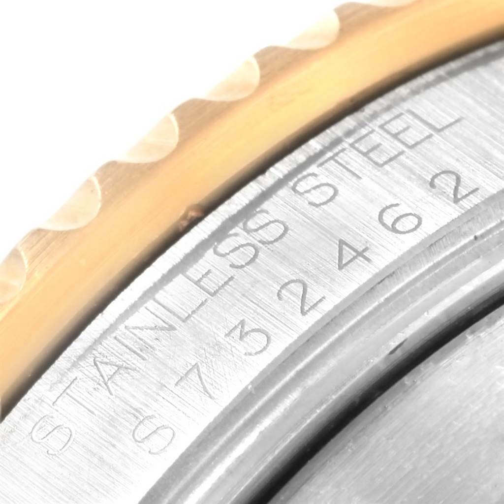 This close-up image shows the edge of the bezel and part of the case of a Rolex Submariner 16613 Men's Steel and Gold (two tone) Blue Dial 16613 Men's Steel and Gold (two tone) Blue Dial watch, highlighting the engraving "STAINLESS STEEL" and serial number.