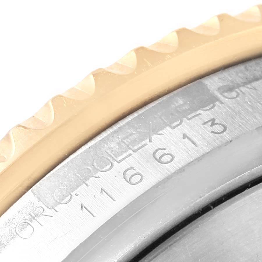 The image shows a close-up of the Rolex Submariner 116613 Men's Steel and Gold (two tone) Blue Dial 116613 Men's Steel and Gold (two tone) Blue Dial's bezel and part of the engraved case back.