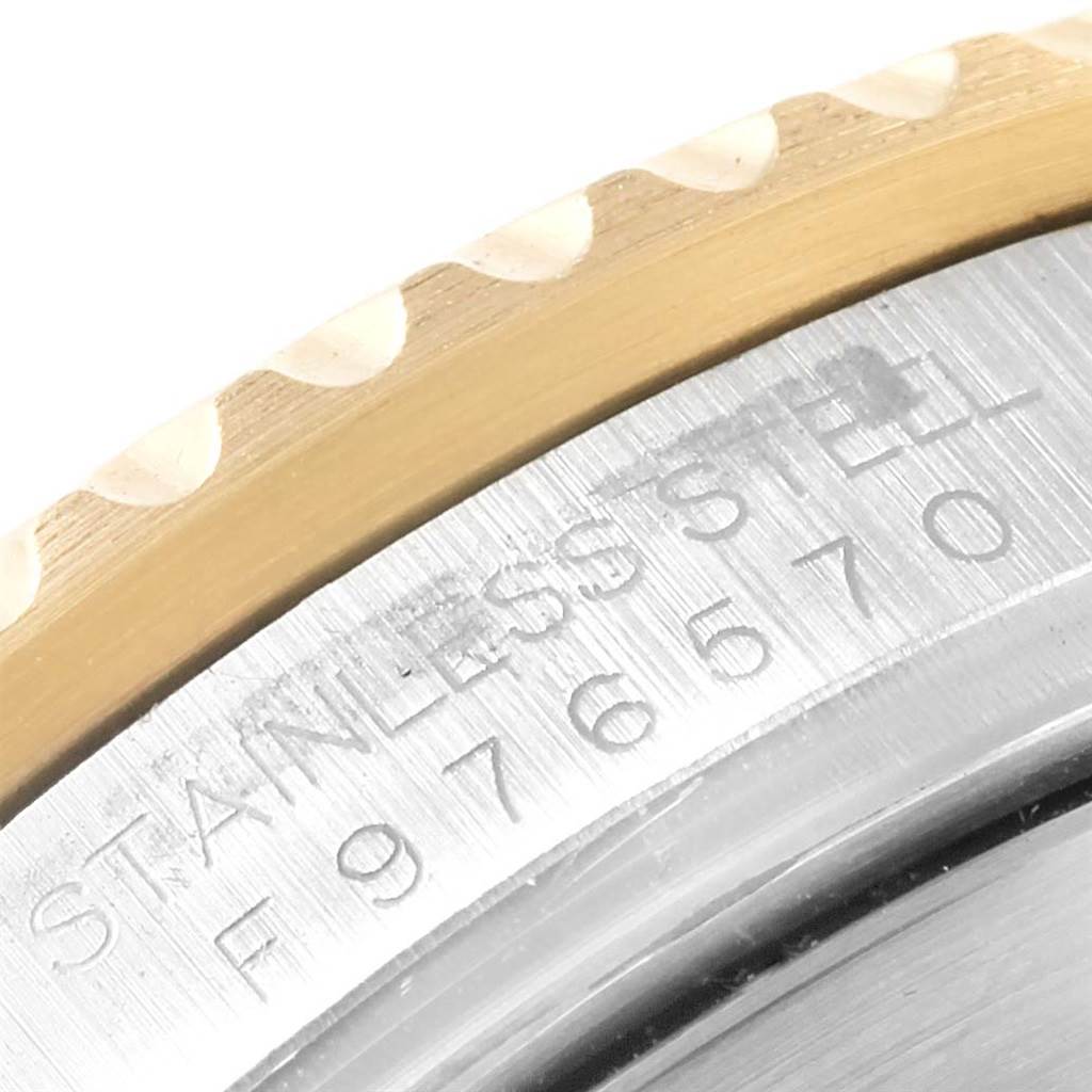 The image shows a close-up of the side view of the Rolex Submariner 16613 Men's Steel and Gold (two tone) Blue Dial 16613 Men's Steel and Gold (two tone) Blue Dial watch focusing on the bezel and engraved serial number.