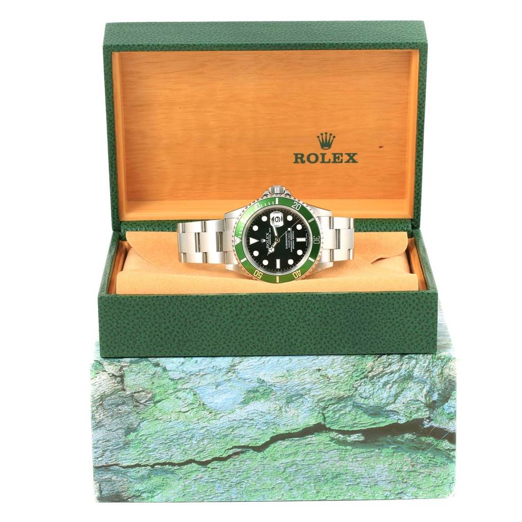 The Rolex Submariner 16610LV Men's Stainless Steel Black Dial 16610LV Men's Stainless Steel Black Dial watch is displayed front-facing inside an open green and beige box with the Rolex logo.