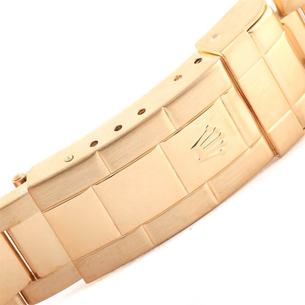 This image shows a close-up of the clasp and bracelet of a Rolex Submariner 16618 Men
s Yellow Gold Black Dial 16618 Men
s Yellow Gold Black Dial watch in a gold finish.