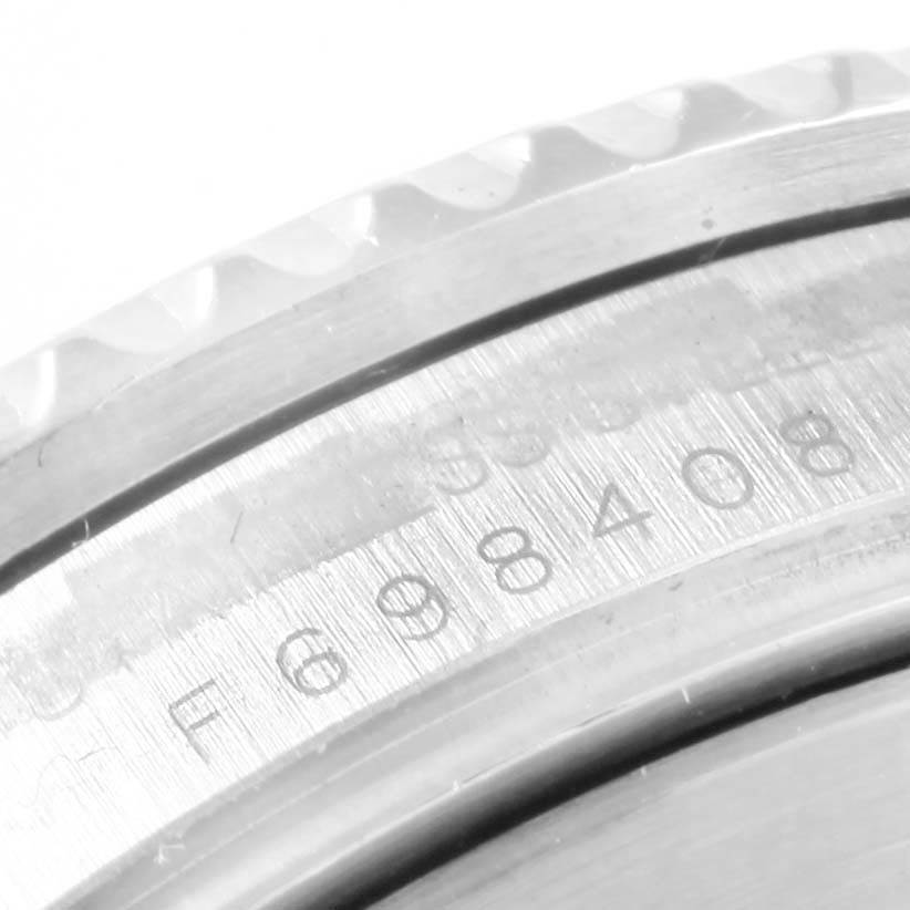 The image shows a close-up of a serial number inscribed on the polished metal case of a Rolex Submariner 16610 Men's Stainless Steel Black Dial 16610 Men's Stainless Steel Black Dial watch.