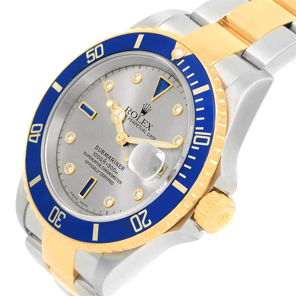 The image shows a side angle of a Rolex Submariner 16613 Men's Steel and Gold (two tone) Grey Dial 16613 Men's Steel and Gold (two tone) Grey Dial watch, highlighting the blue bezel, dial, crown, and part of the bracelet.