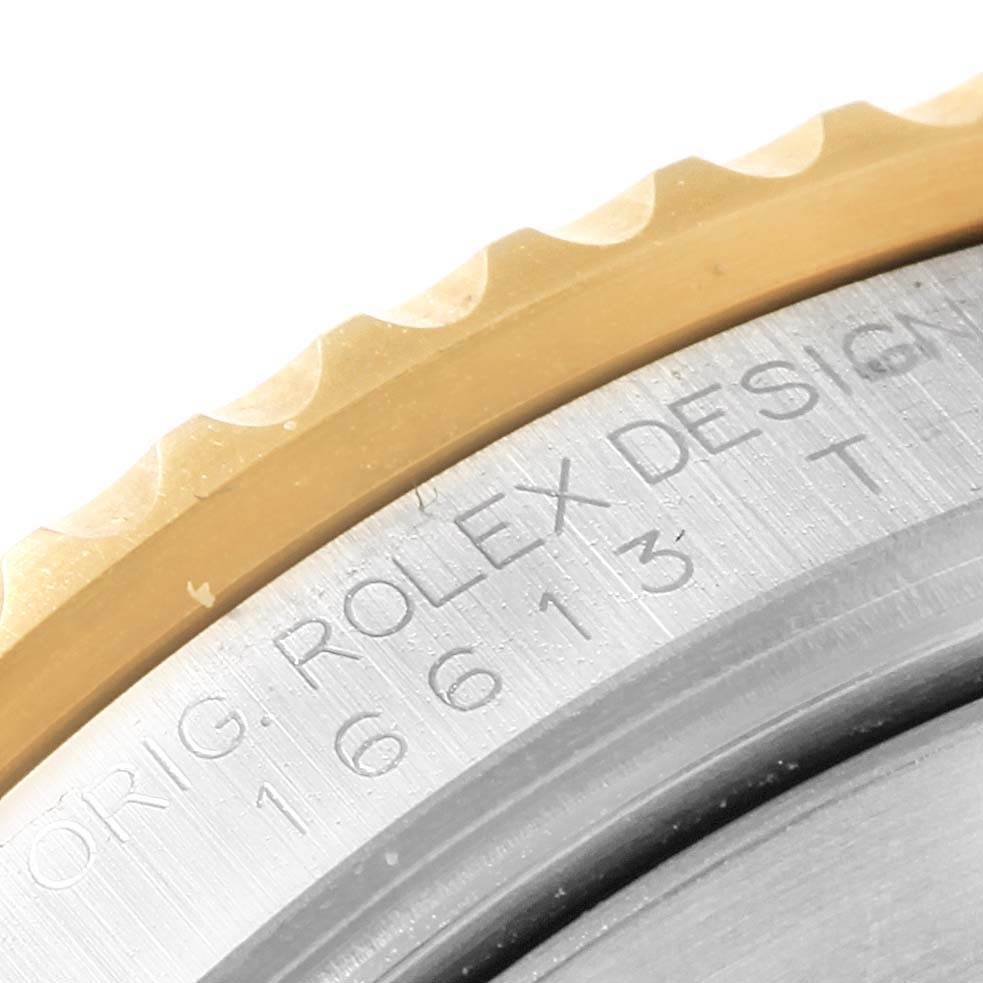 The image shows a close-up of the bezel and part of the case back of a Rolex Submariner 16613 Men's Steel and Gold (two tone) Blue Dial 16613 Men's Steel and Gold (two tone) Blue Dial watch, highlighting the model number and brand engraving.