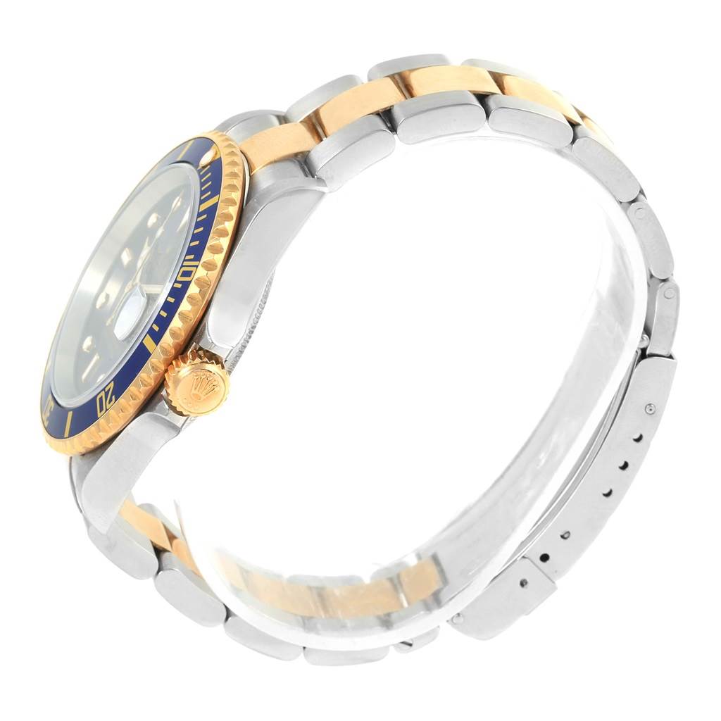 The image shows a side view of a Rolex Submariner 16613 Men's Steel and Gold (two tone) Blue Dial 16613 Men's Steel and Gold (two tone) Blue Dial watch, highlighting the crown, bezel, and two-tone strap.