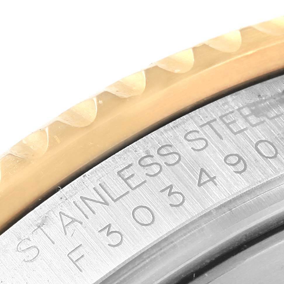 The image shows a close-up of the side of a Rolex Submariner 16613 Men's Steel and Gold (two tone) Blue Dial 16613 Men's Steel and Gold (two tone) Blue Dial watch, highlighting the engraved text on the stainless steel case and the edge of the bezel.