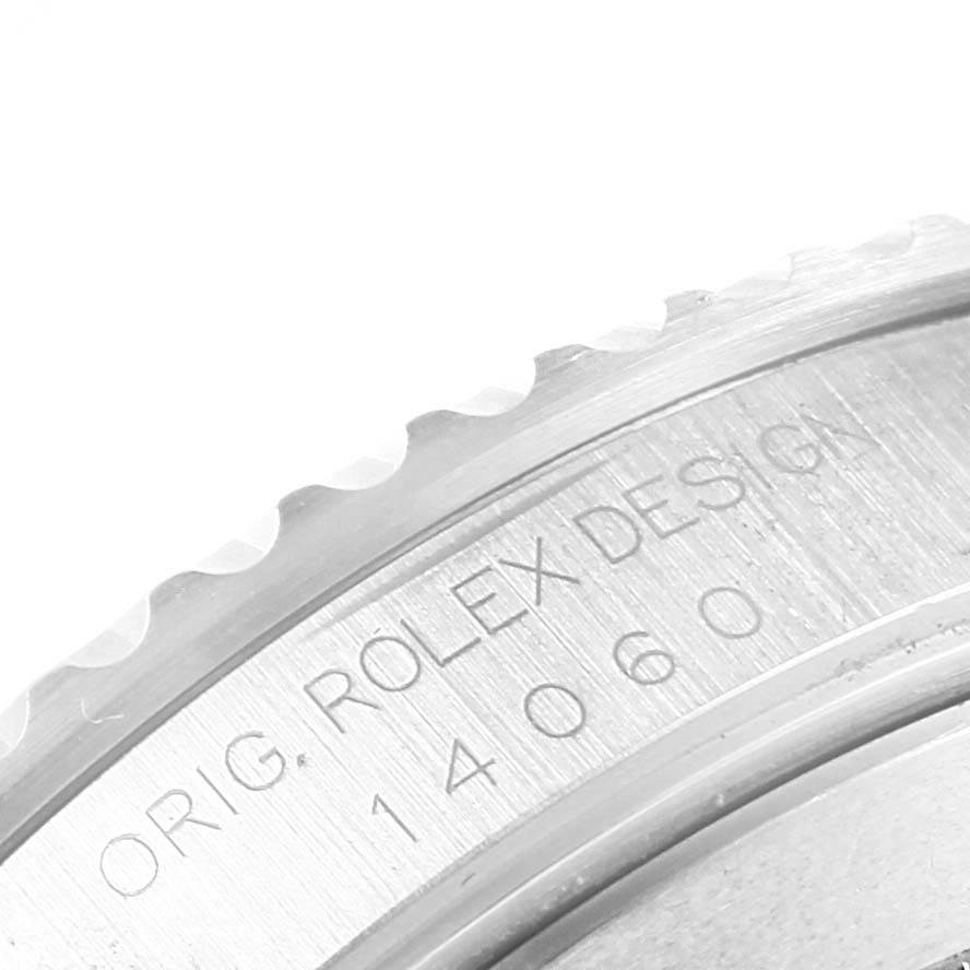 This image shows a close-up of the bezel and engraved serial number of a Rolex Submariner 14060 Men's Stainless Steel Black Dial 14060 Men's Stainless Steel Black Dial watch.
