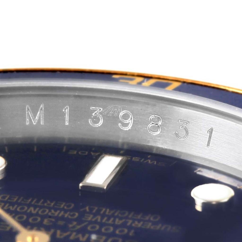 The image shows a close-up of the serial number engraved on the inner bezel and a portion of the dial of a Rolex Submariner 16613 Men's Steel and Gold (two tone) Blue Dial 16613 Men's Steel and Gold (two tone) Blue Dial watch.