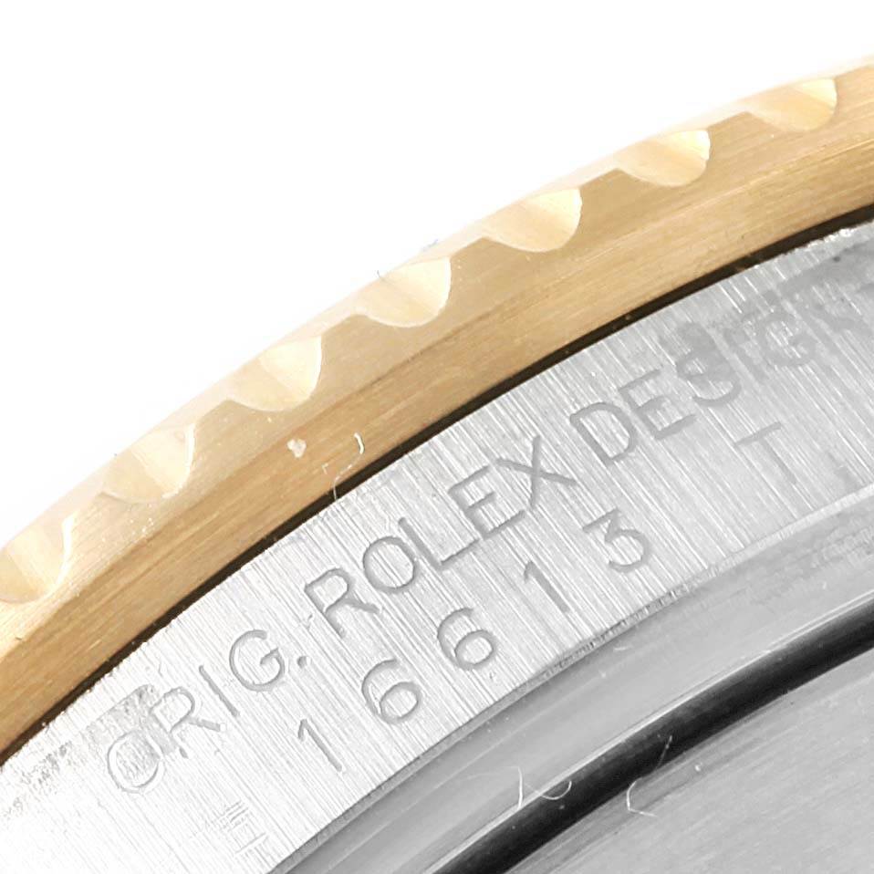 This angle shows a close-up of the bezel and part of the case back with the model number engraving on a Rolex Submariner 16613 Men's Steel and Gold (two tone) Blue Dial 16613 Men's Steel and Gold (two tone) Blue Dial.