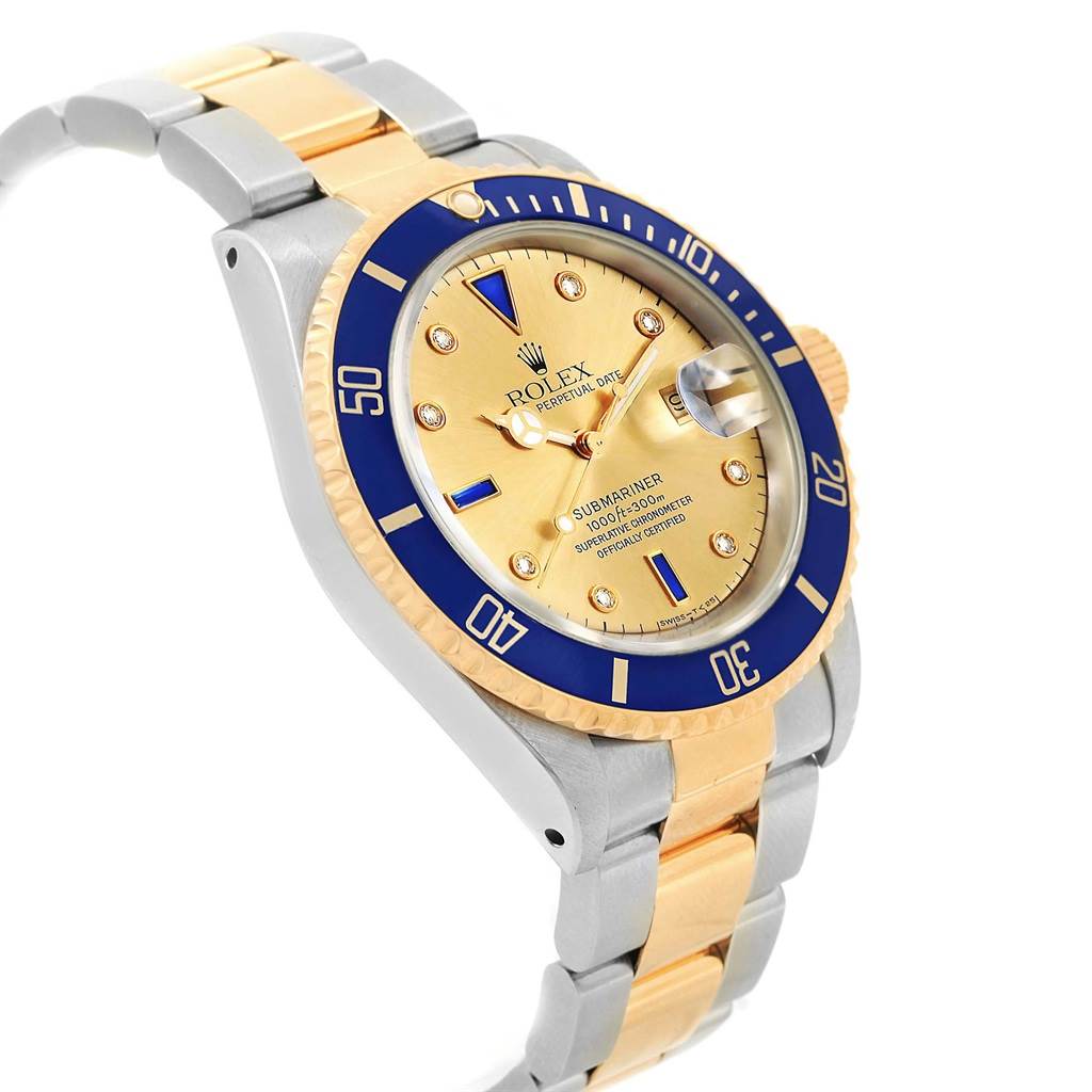 The image shows a Rolex Submariner 16613 Men's Steel and Gold (two tone) Champagne Dial 16613 Men's Steel and Gold (two tone) Champagne Dial at an angle highlighting its gold and blue bezel, gold dial, and two-tone bracelet.