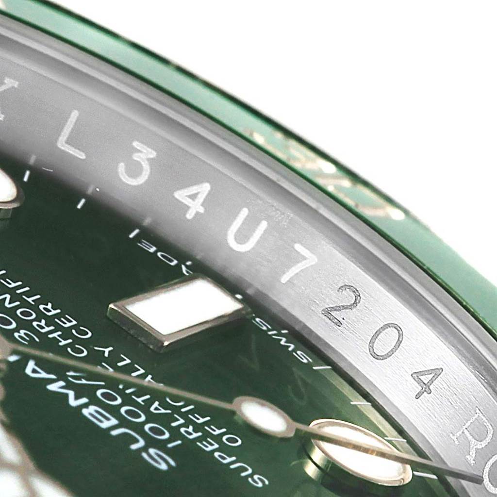 This close-up of a Rolex Submariner 116610LV Men
s Stainless Steel Green Dial 116610LV Men
s Stainless Steel Green Dial shows part of the dial, rehaut with engraving, and the minute hand.
