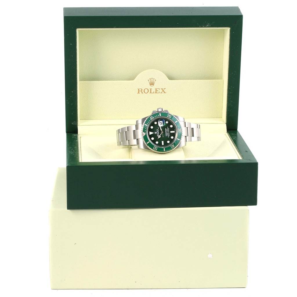 The image shows a Rolex Submariner 116610LV Men
s Stainless Steel Green Dial 116610LV Men
s Stainless Steel Green Dial watch placed inside its open green and beige box, with the face and bracelet visible.