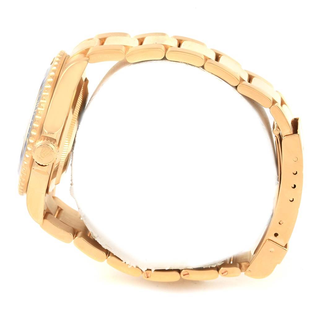 The image shows a side view of a Rolex Submariner 16618 Men's Yellow Gold Blue Dial 16618 Men's Yellow Gold Blue Dial watch, focusing on its gold bracelet, crown, and clasp.