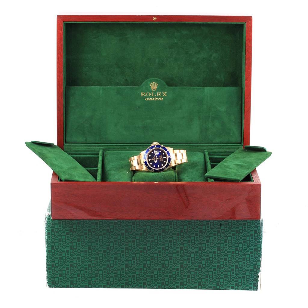 The image shows a Rolex Submariner 16618 Men's Yellow Gold Blue Dial 16618 Men's Yellow Gold Blue Dial watch in its open presentation box, highlighting the watch and luxurious packaging.