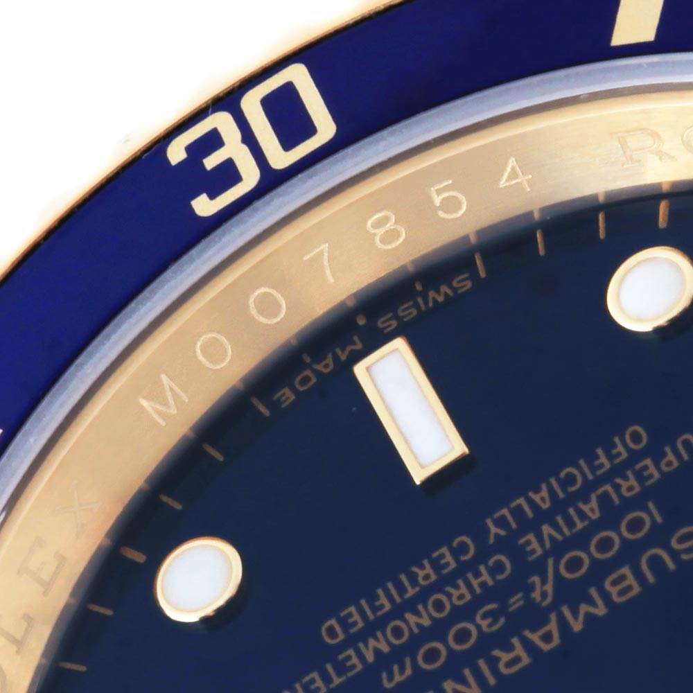This close-up image shows the bezel, part of the dial, and the Swiss Made label of a Rolex Submariner 16618 Men's Yellow Gold Blue Dial 16618 Men's Yellow Gold Blue Dial watch.