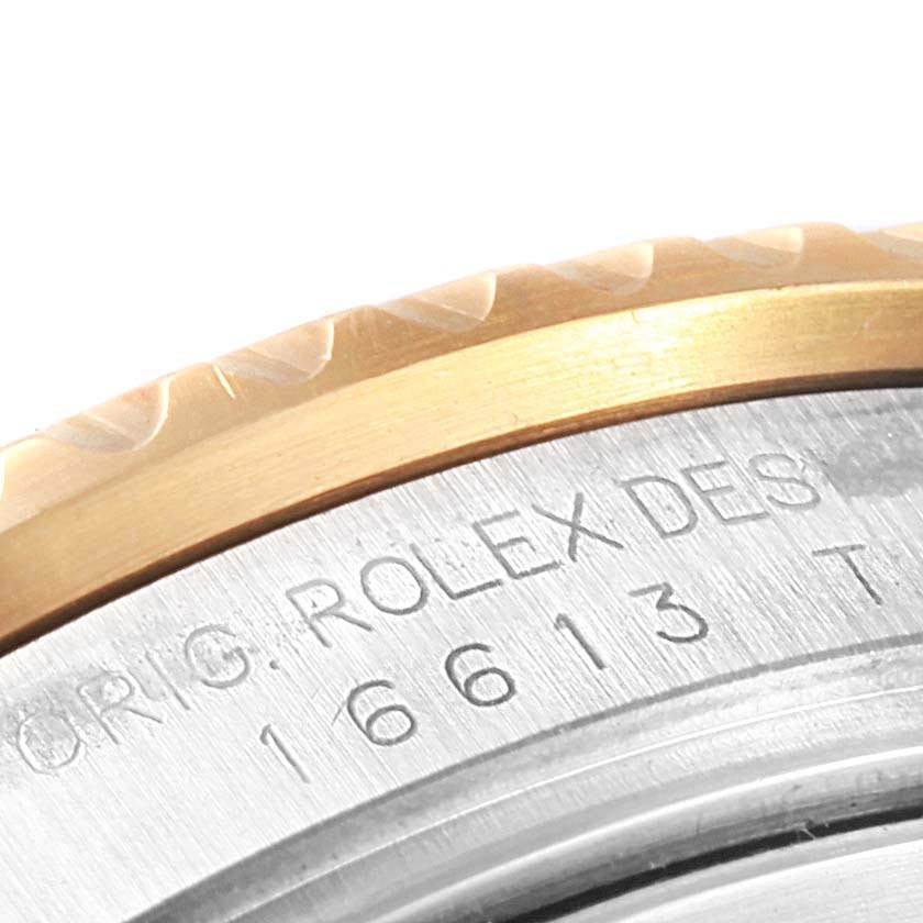 The image shows a close-up of the engraved side of the bezel and case on a Rolex Submariner 16613 Men's Steel and Gold (two tone) Black Dial 16613 Men's Steel and Gold (two tone) Black Dial watch.