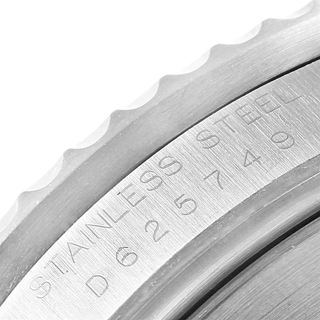 This close-up image shows the engraved serial number and part of the bezel on a Rolex Submariner 16610 Men's Stainless Steel Black Dial 16610 Men's Stainless Steel Black Dial watch.