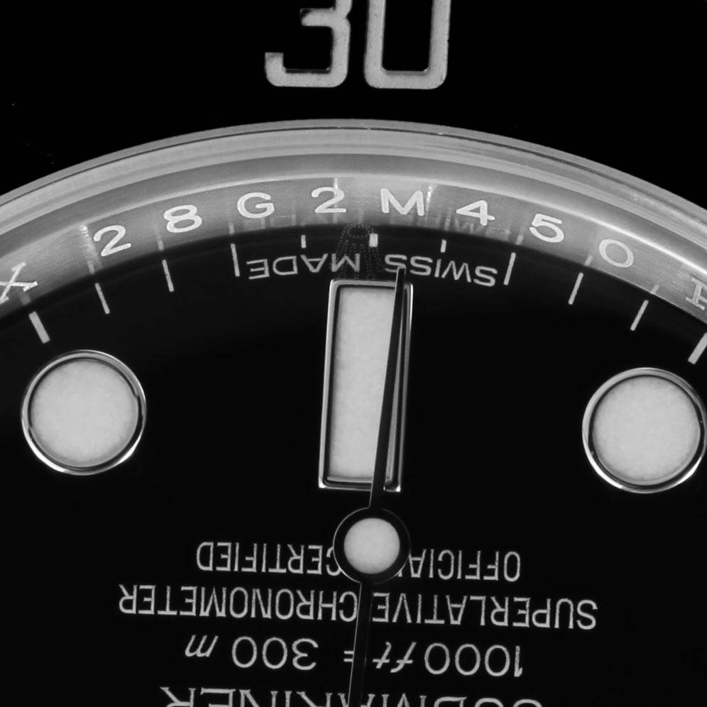 This is a close-up view of the Rolex Submariner 114060 Men's Stainless Steel Black Dial 114060 Men's Stainless Steel Black Dial watch face, focusing on the dial markings and a portion of the hands.