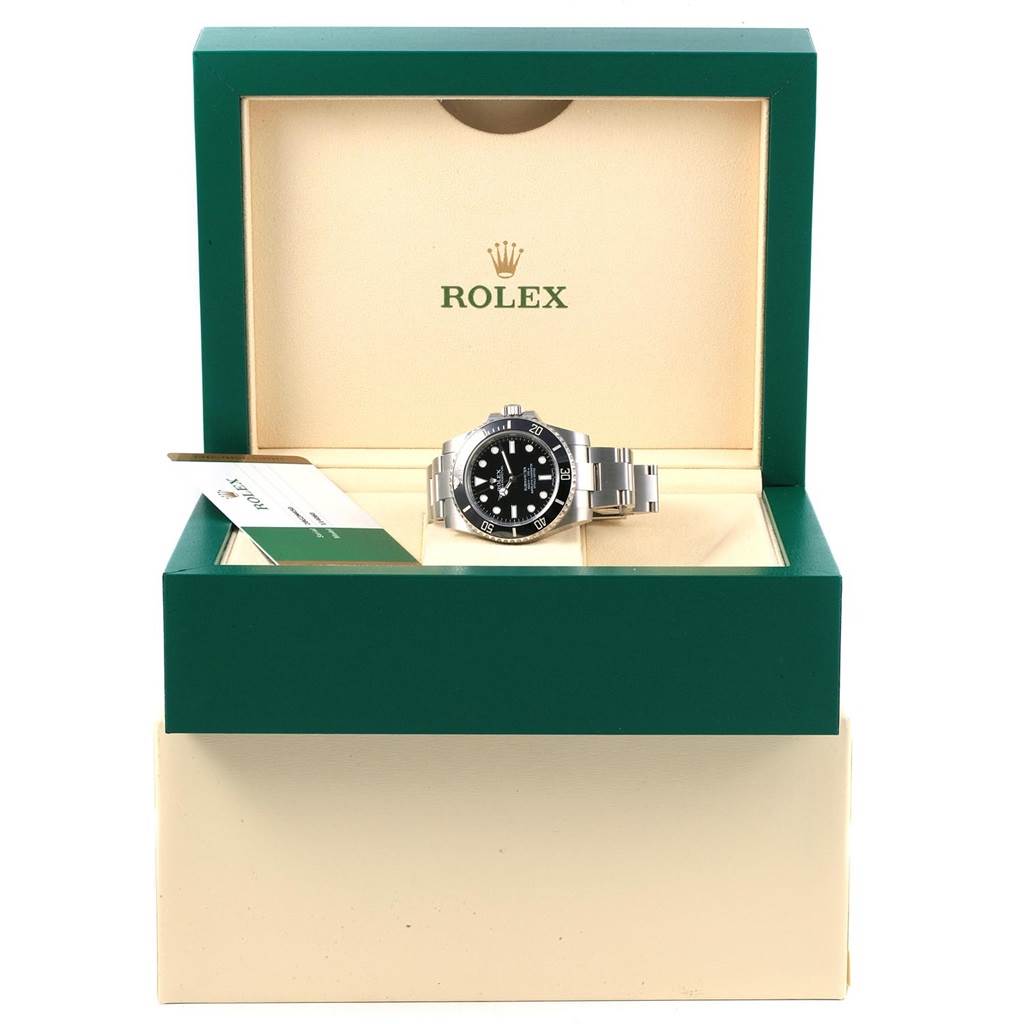 The Rolex Submariner 114060 Men's Stainless Steel Black Dial 114060 Men's Stainless Steel Black Dial watch is shown front-on in its open green and beige box, with the bracelet and bezel clearly visible.