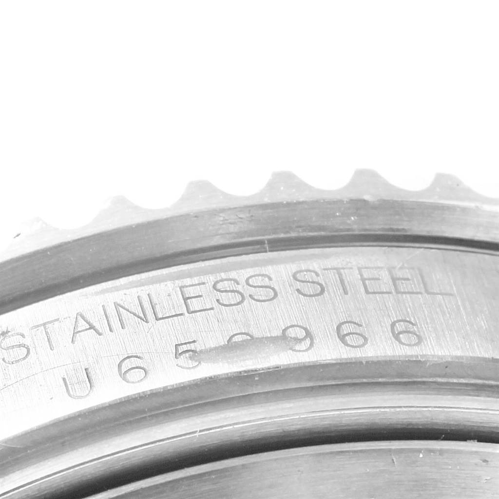 The image shows a close-up of the bezel and part of the case back of a Rolex Submariner 16610 Men's Stainless Steel Black Dial 16610 Men's Stainless Steel Black Dial, highlighting the stainless steel engraving.