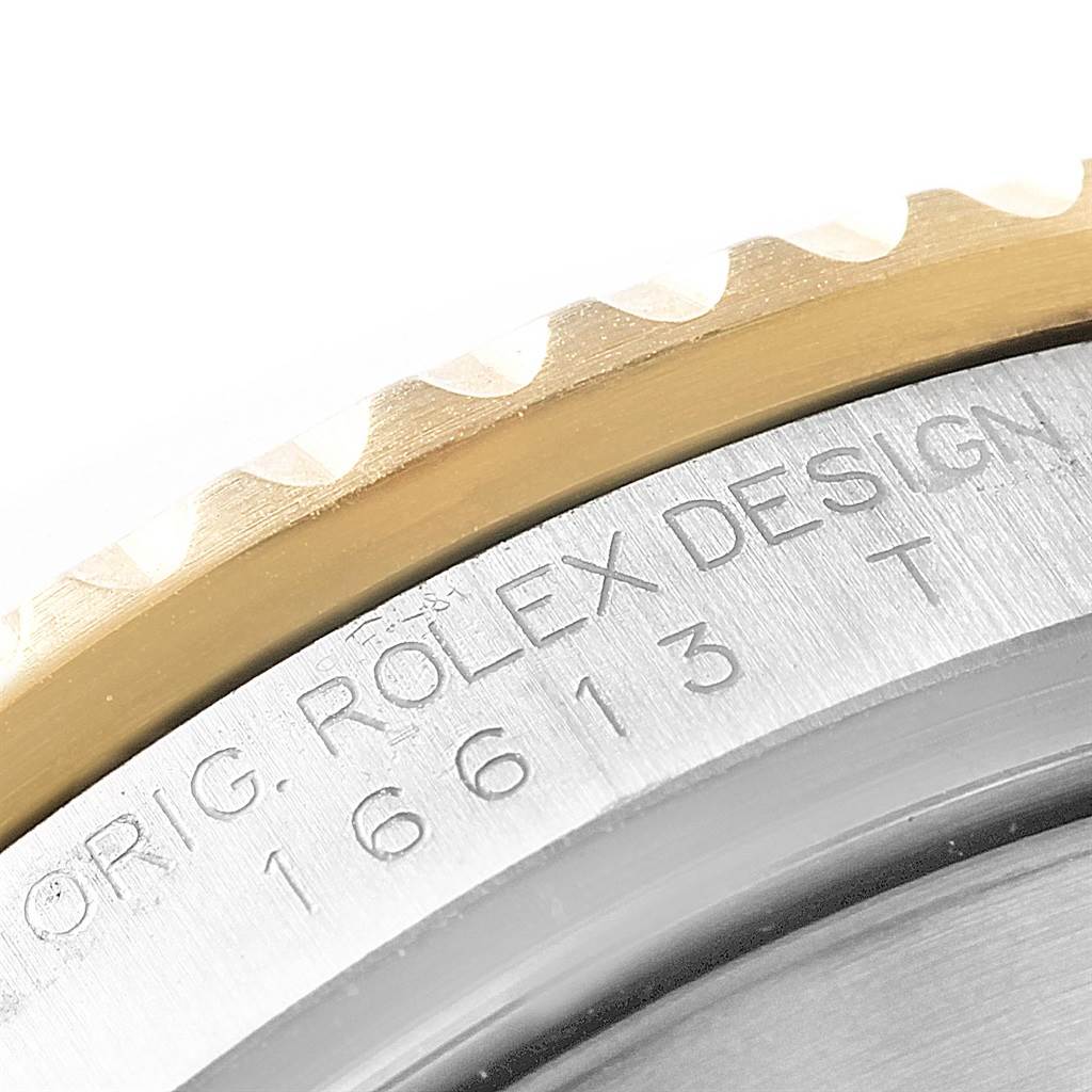 This image shows a close-up view of the Rolex Submariner 16613 Men's Steel and Gold (two tone) Blue Dial 16613 Men's Steel and Gold (two tone) Blue Dial's bezel and case back, highlighting the engraved model number and branding.