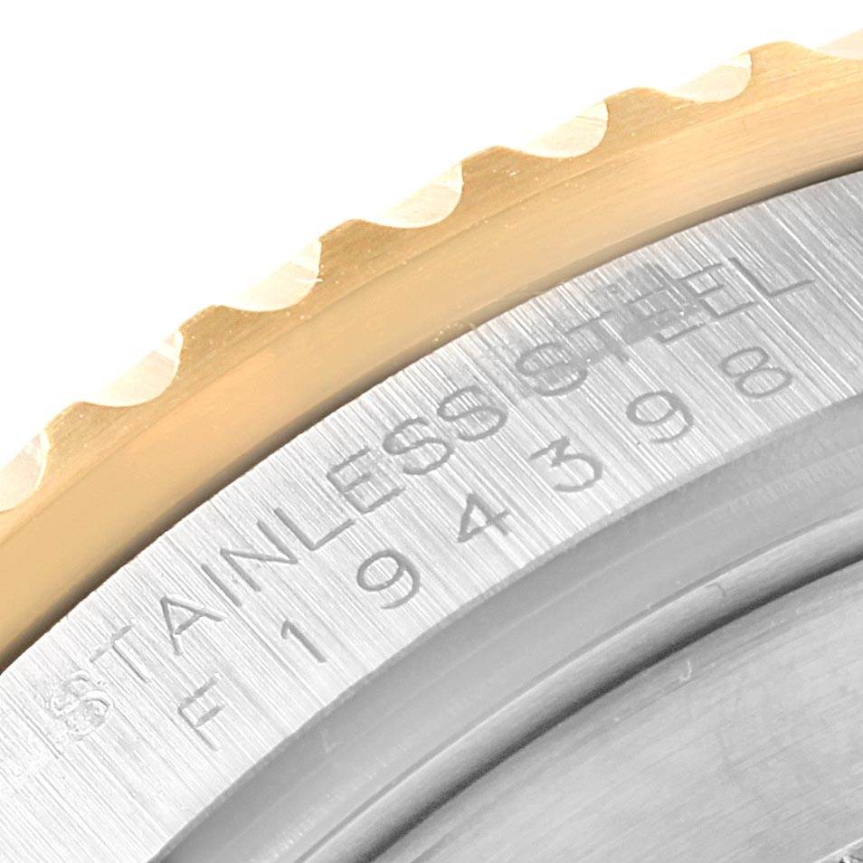 This close-up image of a Rolex Submariner 16613 Men's Steel and Gold (two tone) Blue Dial 16613 Men's Steel and Gold (two tone) Blue Dial shows the engraved serial number section and part of the bezel.