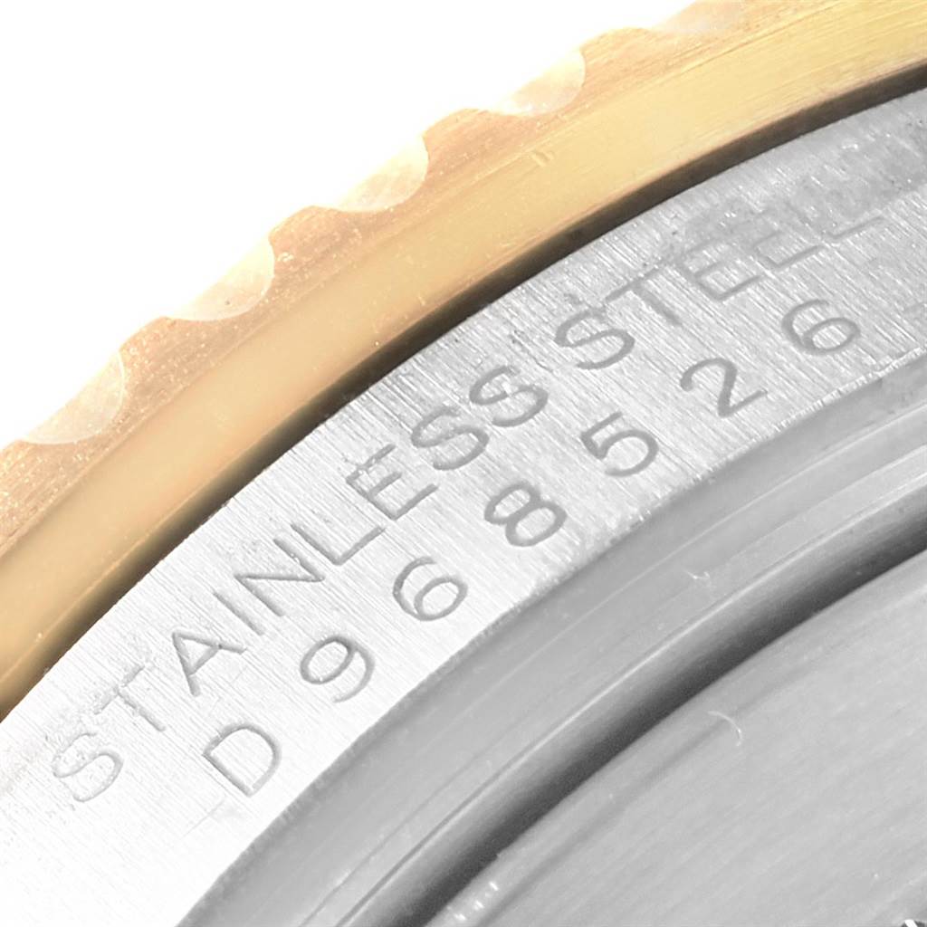 The image shows a close-up of the outer edge and part of the case back of a Rolex Submariner 16613 Men's Steel and Gold (two tone) Grey Dial 16613 Men's Steel and Gold (two tone) Grey Dial watch, featuring its engraving.