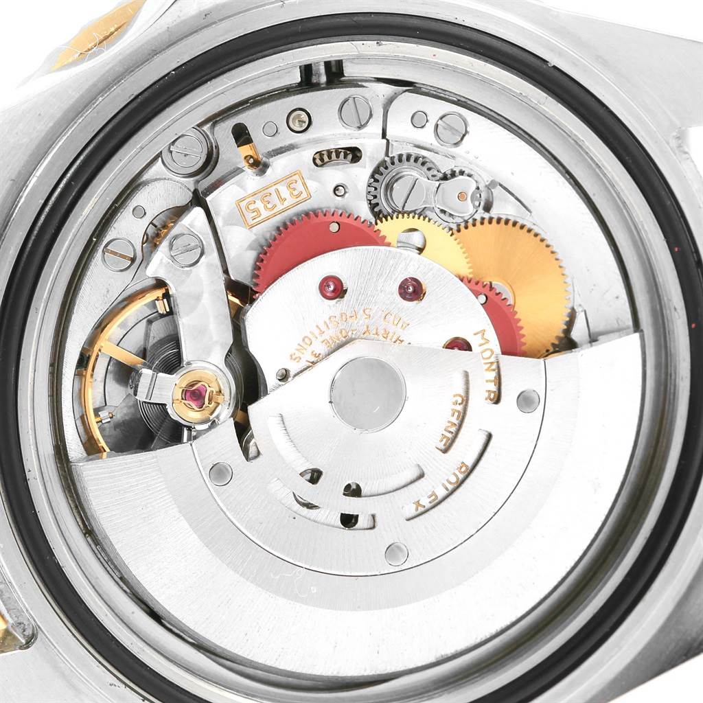 This image shows the intricate inner mechanism of a Rolex Submariner 16613 Men's Steel and Gold (two tone) Grey Dial 16613 Men's Steel and Gold (two tone) Grey Dial watch from a close-up angle.