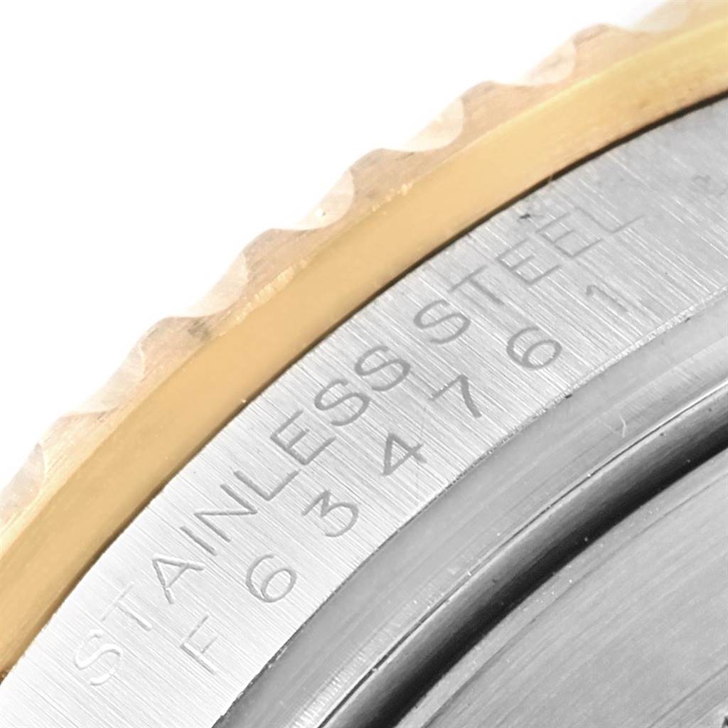 This close-up image shows the engraved text and partially visible bezel of a Rolex Submariner 16613 Men's Steel and Gold (two tone) Champagne Dial 16613 Men's Steel and Gold (two tone) Champagne Dial watch.