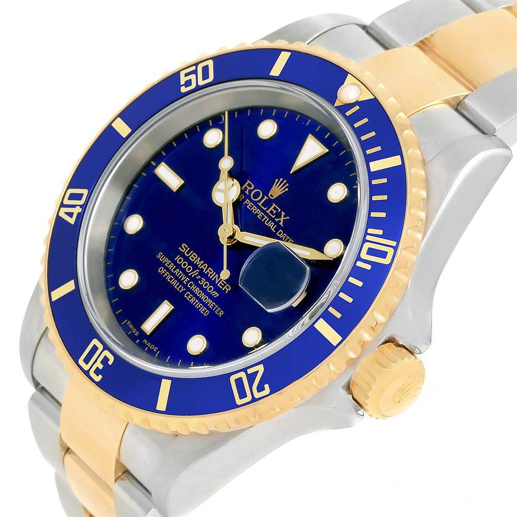 The image shows a close-up angle of a Rolex Submariner 16613 Men's Steel and Gold (two tone) Blue Dial 16613 Men's Steel and Gold (two tone) Blue Dial watch, highlighting its blue dial, bezel, crown, and two-tone bracelet.