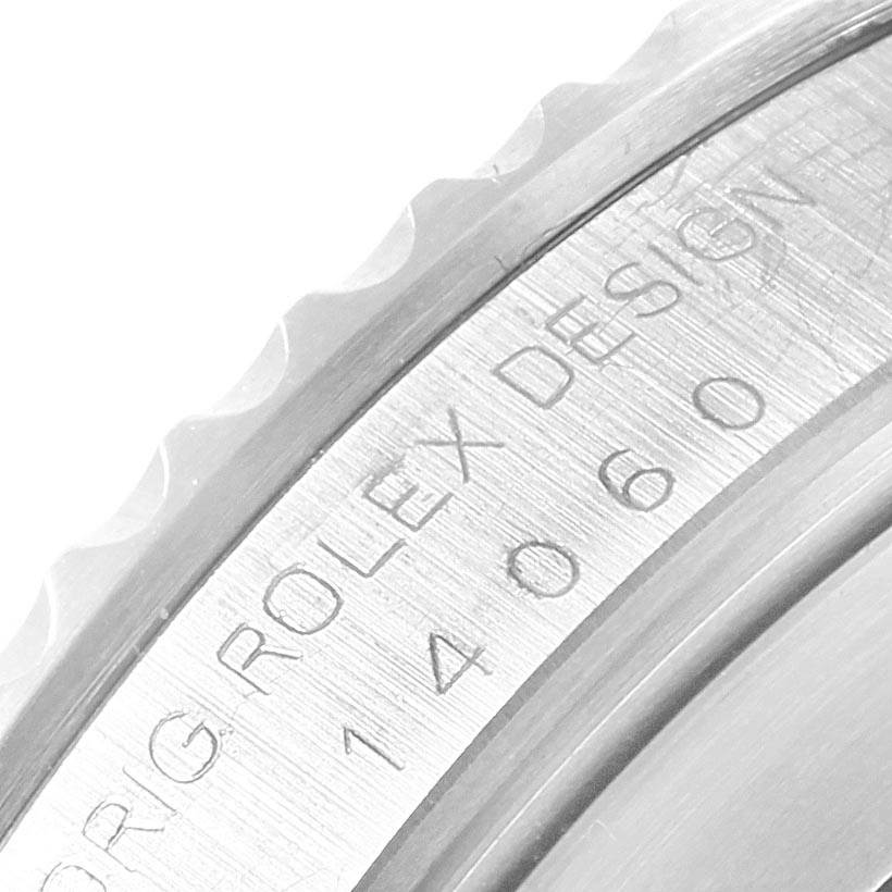 This image shows a close-up of the engraved bezel and case back of a Rolex Submariner 14060 Men's Stainless Steel Black Dial 14060 Men's Stainless Steel Black Dial model.