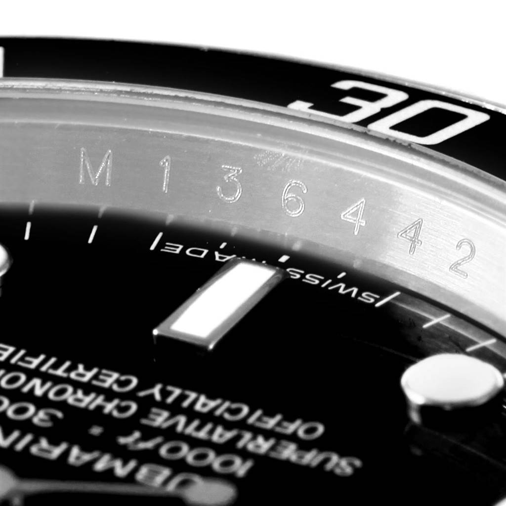 Close-up of the Rolex Submariner 14060 Men's Stainless Steel Black Dial 14060 Men's Stainless Steel Black Dial watch showing the engraved bezel, chapter ring, and part of the dial with text and markers.