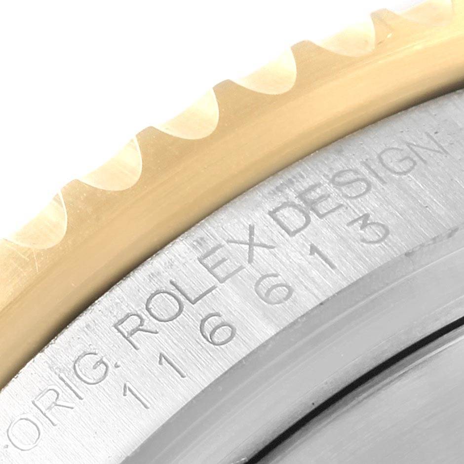 The image shows a close-up of the bezel and case side of a Rolex Submariner 116613 Men's Steel and Gold (two tone) Blue Dial 116613 Men's Steel and Gold (two tone) Blue Dial watch, highlighting its metal components and serial engraving.